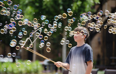 Boy watching bubbles blowing across in front of him