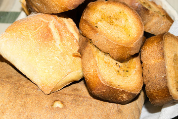 Cesto ripieno di panini e fette di pane tostato condito con olio e pepe 