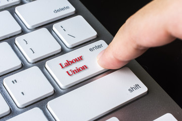 Finger on computer keyboard keys with Labour Union word