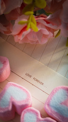 Artificial roses, brown paper and pink marshmallows