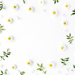 Frame of chamomiles, branches, leaves and lilac petals on white background. Flat lay, top view