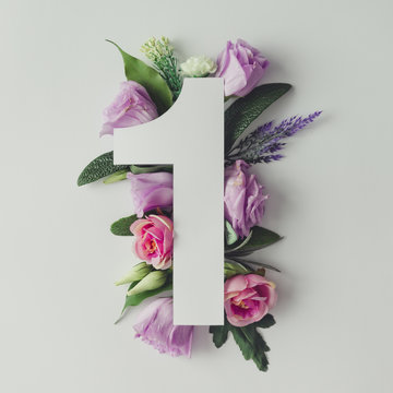 Creative layout with colorful flowers, leaves and number one. An