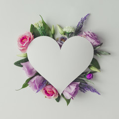 Creative layout with colorful flowers, leaves and heart shape. A