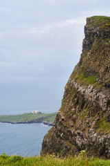 Fototapeta na wymiar Looking down onto Neist Point lighthouse from Ramasaig cliffs near Dunvegan on the Isle of Skye, Scotland, UK. 