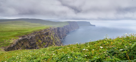 The misty sea cliffs of Ramasaig as wet weather approaches. Isle of Skye, Scotland, UK.      