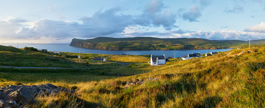 White painted houses of Milovaig at sunset overlooking Loch Pooltiel near Dunvegan on the Isle of Skye, Scotland, UK.      