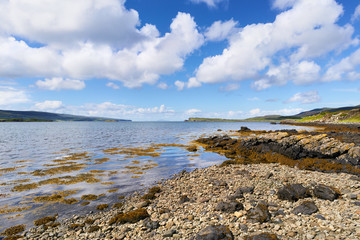 Fototapeta na wymiar Sea views on a sunny day from a pebble beach at Uiginish Point near Dunvegan on the Isle of Skye, Scotland, UK. 