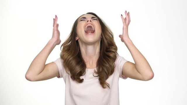 Shocked upset girl shouting and holding hands on her head isolated 
