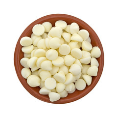 White chocolate baking chips in a small bowl isolated on a white background.