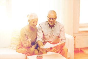 senior couple with papers and calculator at home