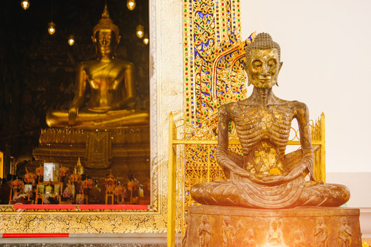 starving Buddha statue with thai art architecture in church Wat Suthat temple. This is a Buddhist temple in Bangkok .