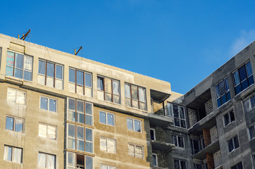 Construction site. Element of unfinished facade against the background of blue sky