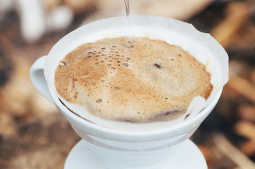 Fresh morning filter coffee blooming in the dripper