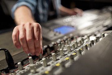 man using mixing console in music recording studio
