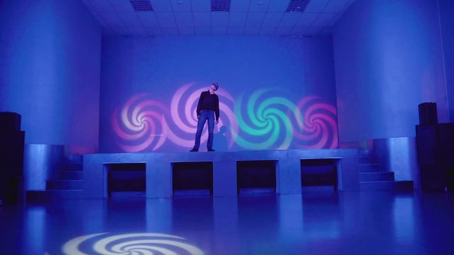 Hypnotized man standing on stage and swinging
