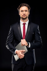 Handsome businessman holding laptop