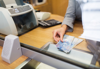 clerk with swiss francs cash money at bank office