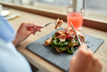 woman eating prosciutto ham salad at restaurant