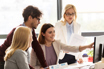 happy creative team with computer in office