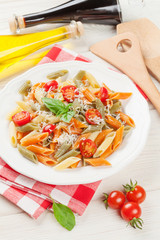 Colorful penne pasta with tomatoes and basil