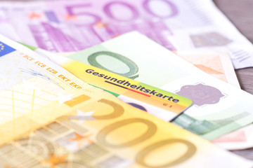 Eine Versichertenkarte einer Krankenkasse und Euro Geld