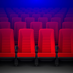 Obraz premium Movie theater with rows of red empty chairs and spotlight, cinema hall seats