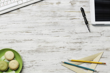 Office workplace with cup and macaroons . Mixed media