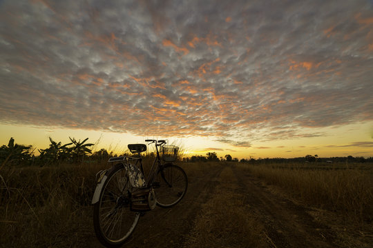 Vintage bicycle on local road with sunrise light background