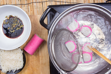 Chef boiling kamaboko (fish cake) in pot