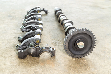 Sport engine camshafts and valves isolated on concrete floor.