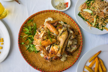 Barbecue chicken serving on bamboo basket on white table, outdoor