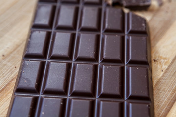 Dark chocolate on a wooden board. Background, texture 