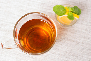 Glass cup of breakfast tea on gentle color background; top view
