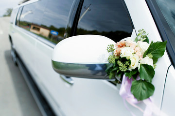 Little bouquet of roses and greenery put on car's mirror
