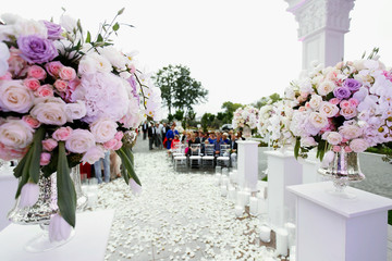 Look from behind large bouquet of roses at path to wedding altar