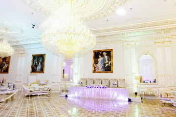 Long dinner table prepared for newlyweds stands in rich wedding