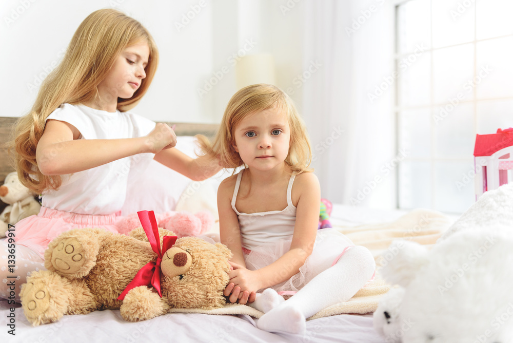 Wall mural Older child taking care of her little sibling