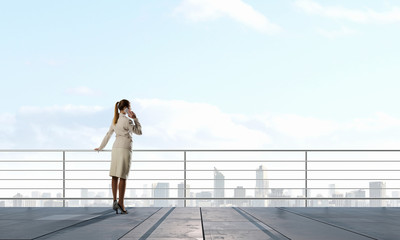 Businesswoman on building roof . Mixed media