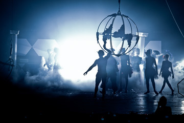 Silhouettes of dancers bringing the steel globe like the whole w