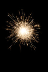 A burning sparkler on a black background