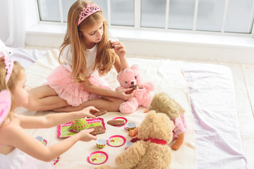 Cute children treating toys with sweets