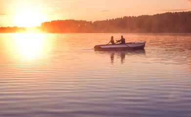 Fototapeta na wymiar Romantic golden sunset river lake fog loving couple small rowing boat Romantic date beautiful Lovers ride boat during beautiful sunset Happy couple woman man together relaxing water nature around
