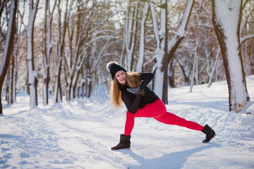 Beautiful woman doing yoga outdoors in the snow