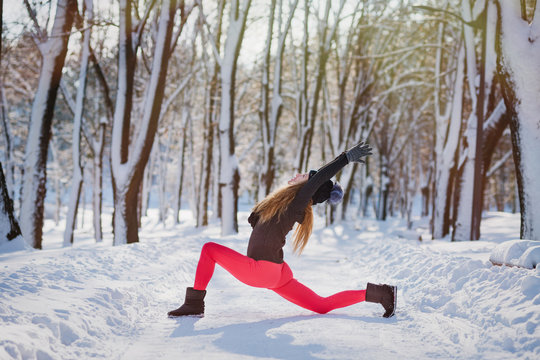 Beautiful Woman Doing Yoga Outdoors In The Snow