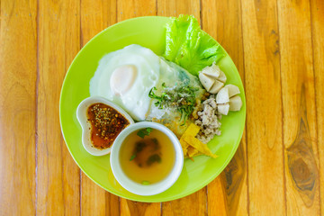 Khao Pan Pak or thai style noodle with fried egg, soup and sauce is the identify foods of Uttaradit,Thailand on the wood table.