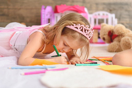 Child drawing pictures in bedroom
