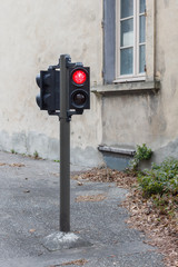 Low simafor with red light for the regulation of traffic on the road. simafor against the...