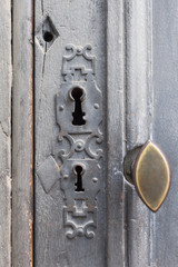keyhole with decor in an old wooden door gray. Closed old door handle. the concept of the protection of the secret