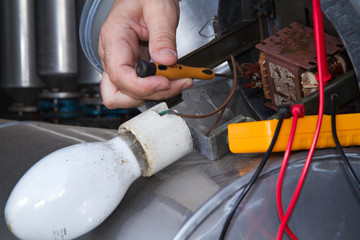 electrician repairing street lamps in a industrial site