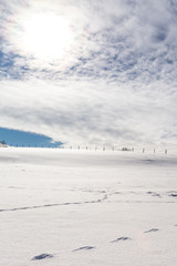 Obraz premium Wolken und Wintersonne über den verschneiten Feldern 